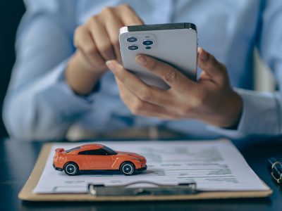 Car rental sales concept, Asian businesswoman working with toy cars on the table. Concepts of cars, property, ownership, insurance and transportation.